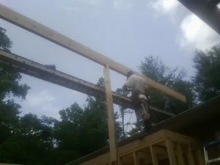 Carpenter setting a ridge beam over a new addition frame — Ice Dam Removal by Roofing Brothers in Fannettsburg