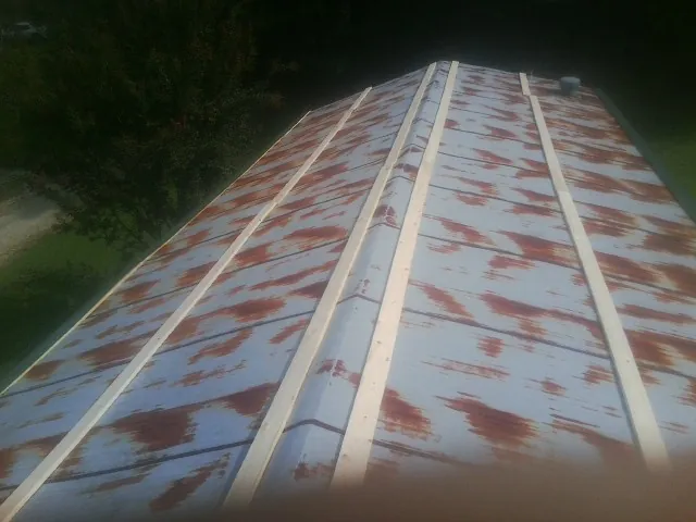 Rusted metal roof panels with new wood purlins before replacement — Storm Damage Roof Repair in Fannettsburg by Roofing Brothers