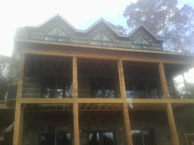 Dormers and porch framing on a large log home under construction — Roof Coating work by our crew in Fannettsburg