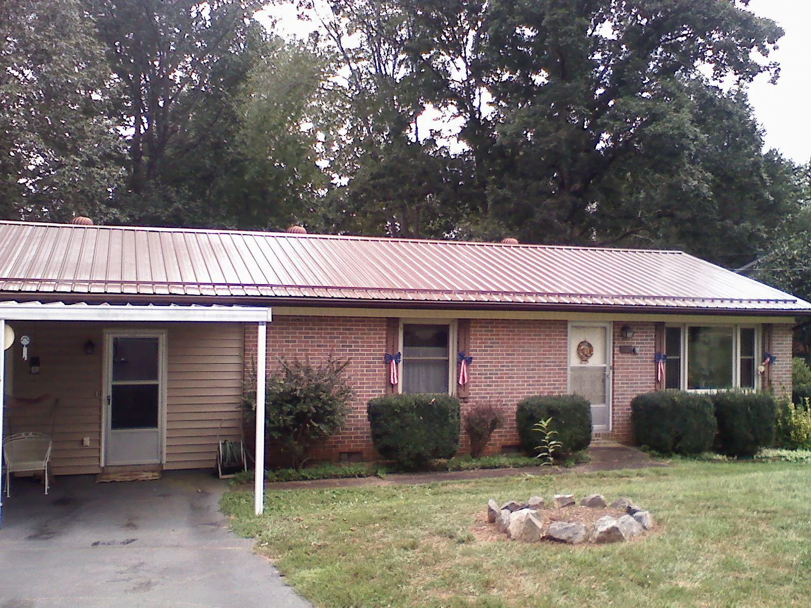 Bronze metal roof and carport on a brick ranch home — Roof Repair work by our crew in Fannettsburg